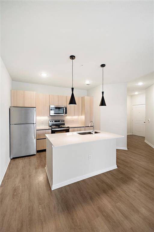 a open kitchen with stainless steel appliances granite countertop a sink a stove and a wooden floors