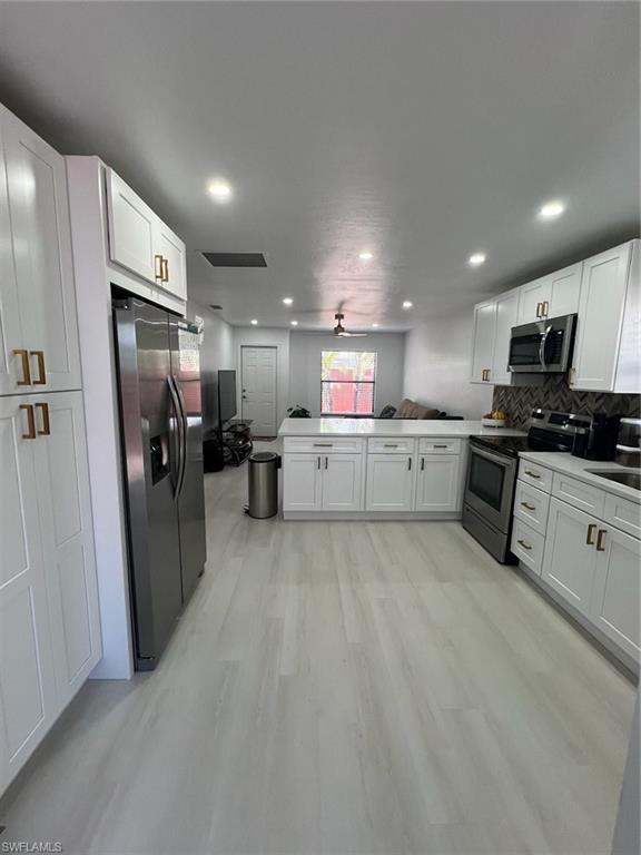 a large kitchen with stainless steel appliances kitchen island granite countertop a refrigerator and a stove top oven