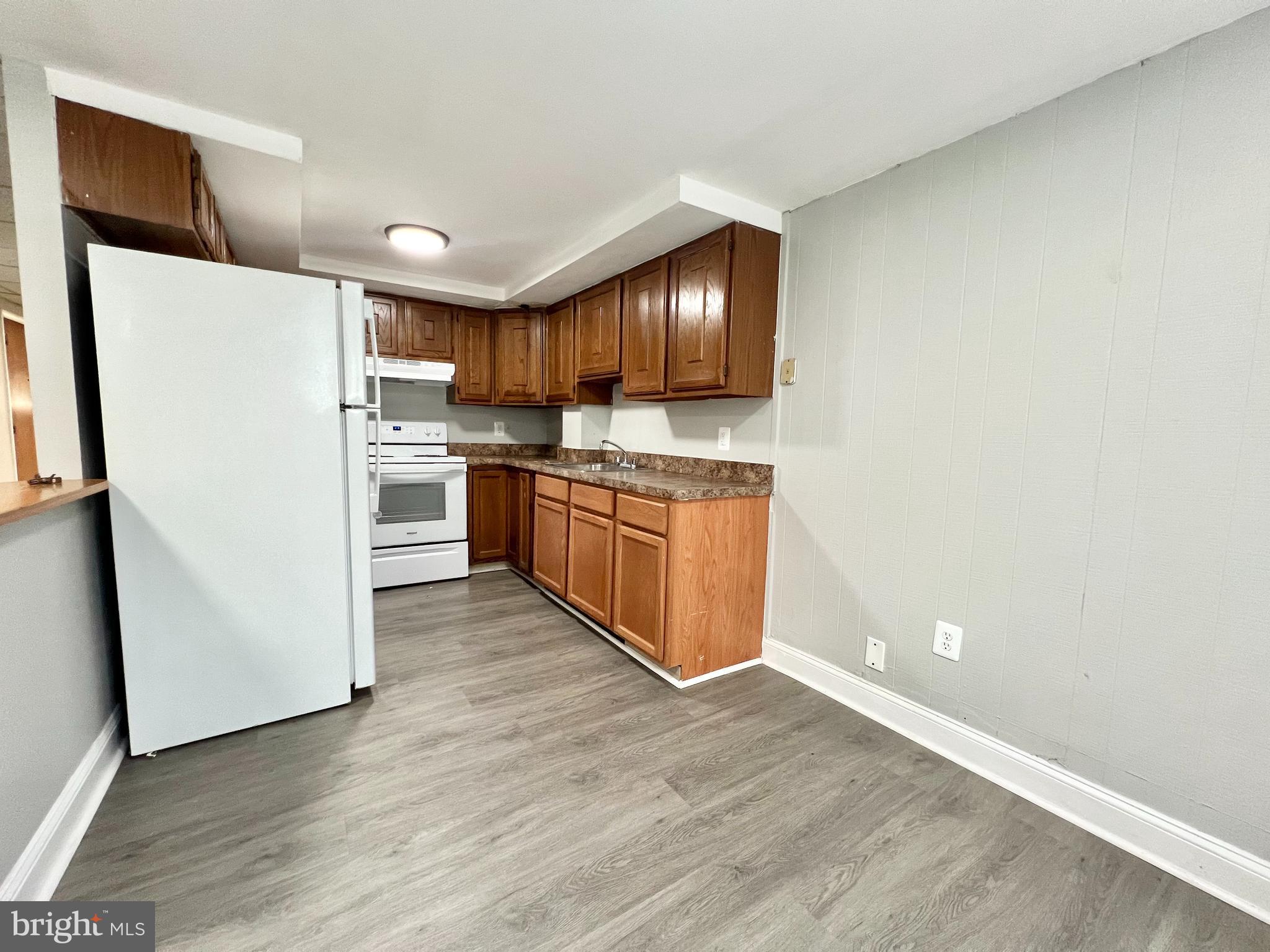 a kitchen with cabinets and wooden floor