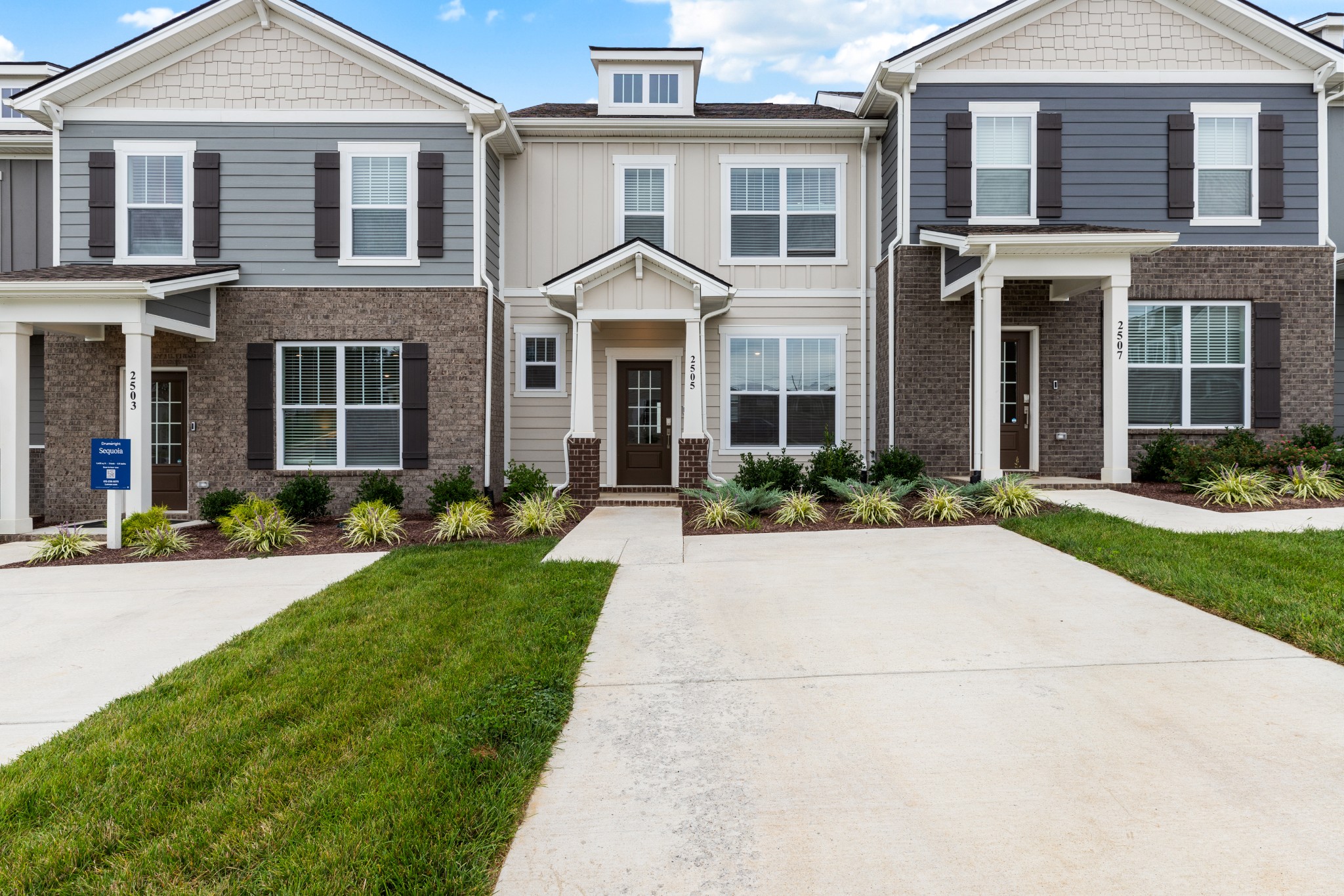 a front view of a house with yard and green space