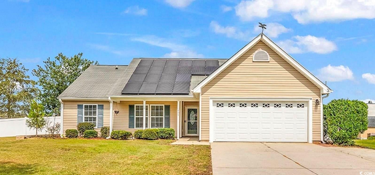 View of front facade with solar panels, a garage,