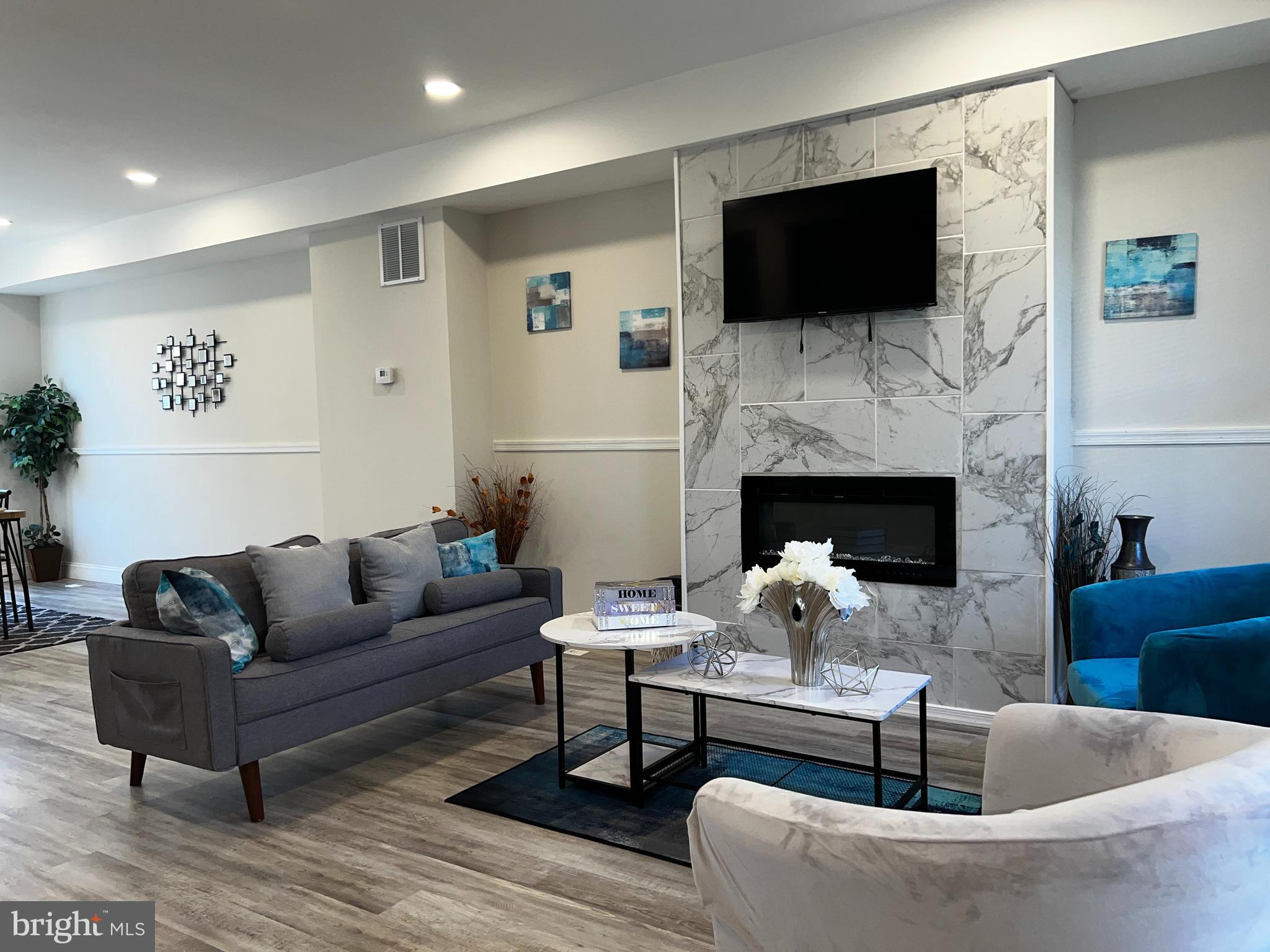 a living room with furniture a flat screen tv and a fireplace