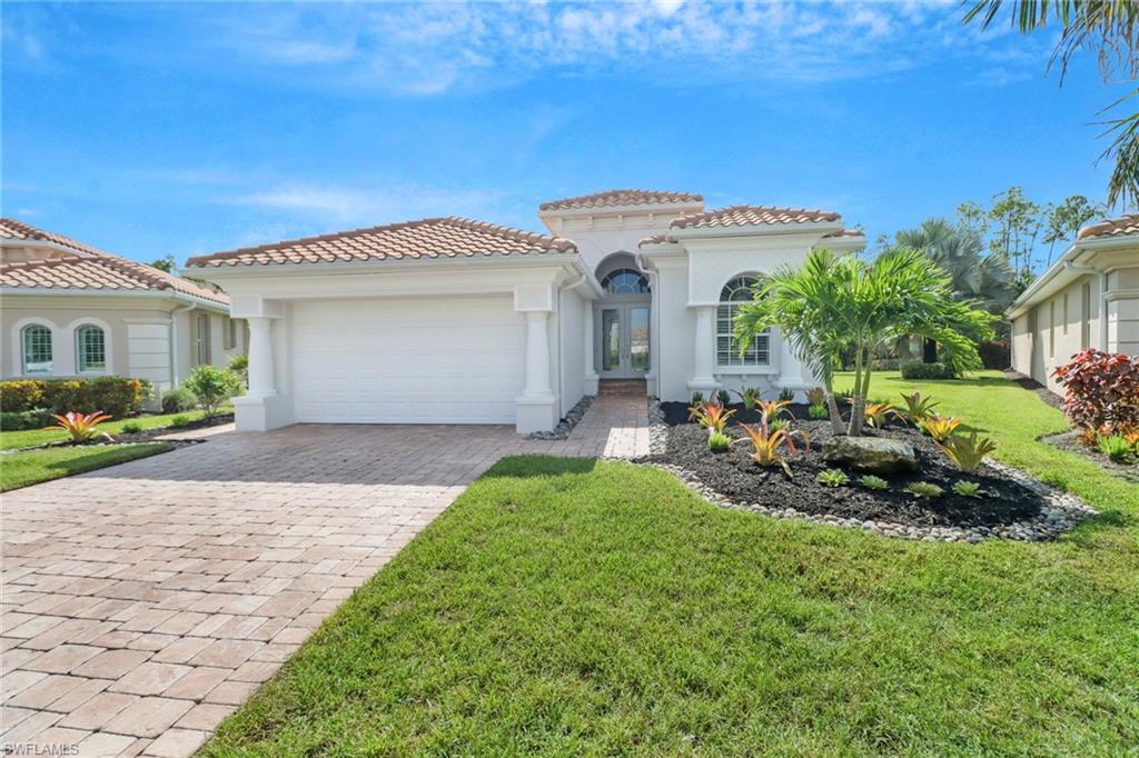 a front view of a house with a garden and yard