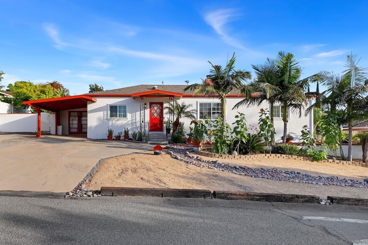 a palm tree sitting in front of a house with a patio