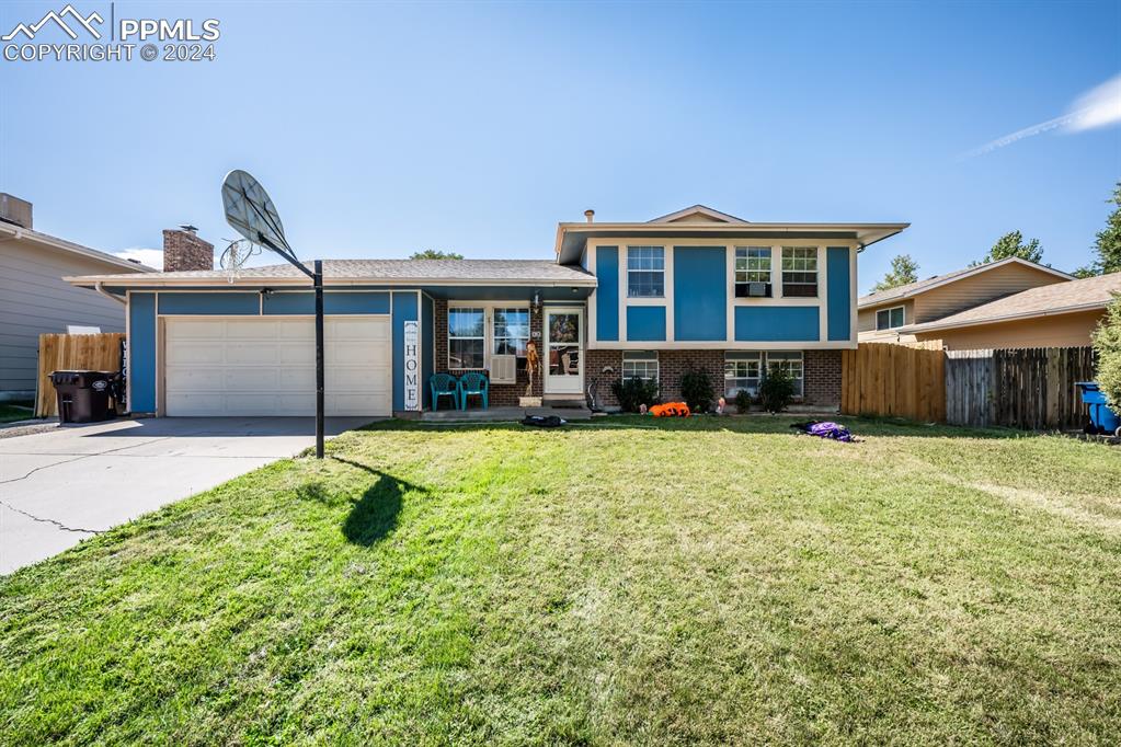 Split level home featuring a front yard and a garage