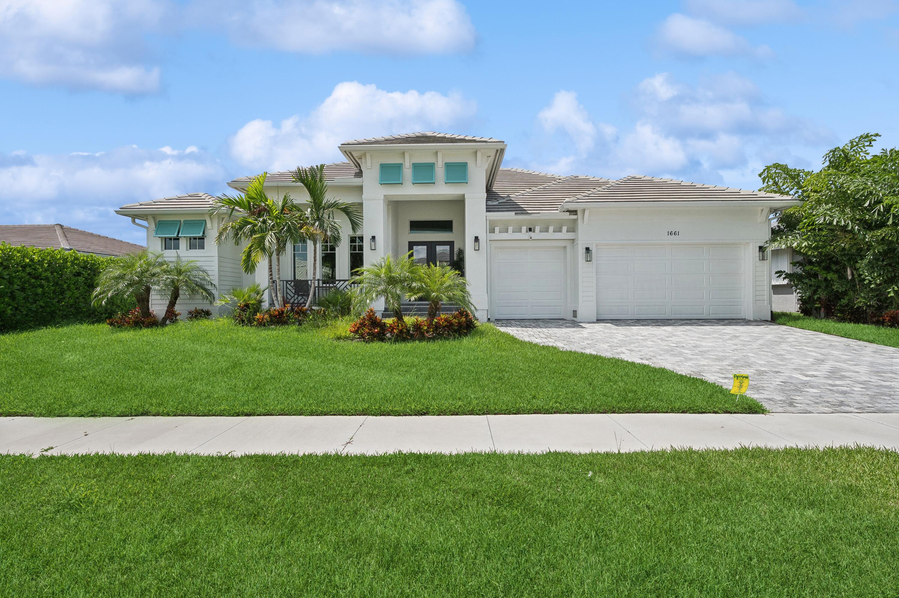 a front view of a house with a garden and plants