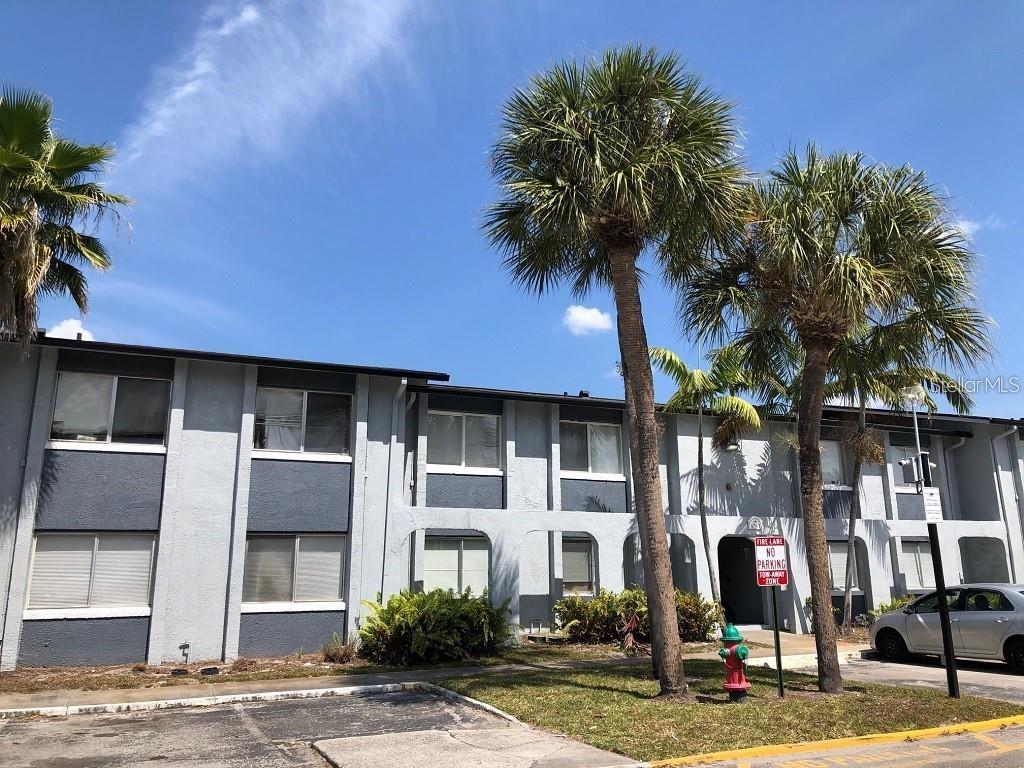 a front view of a building with palm trees