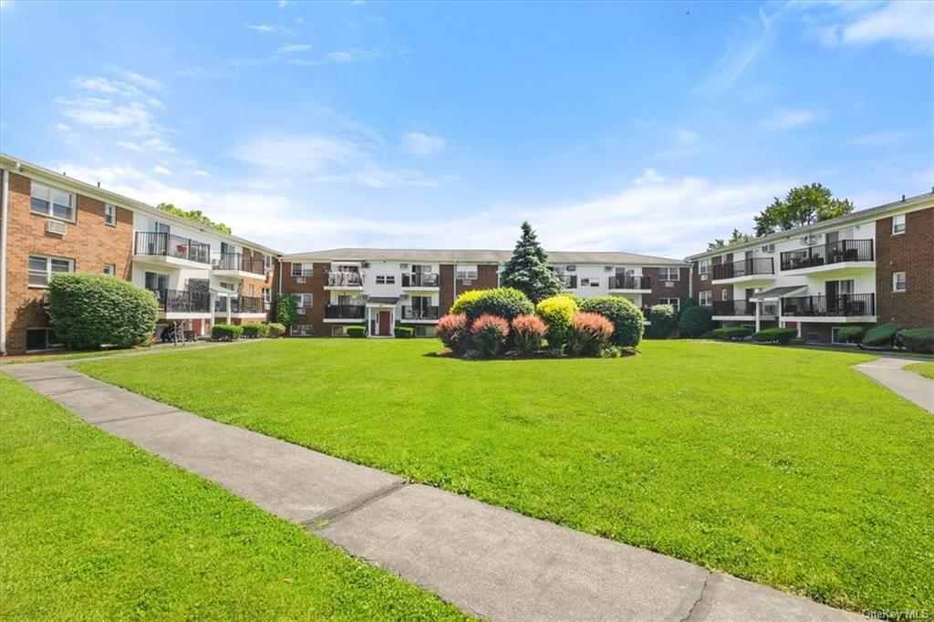 View of property's community with a lawn