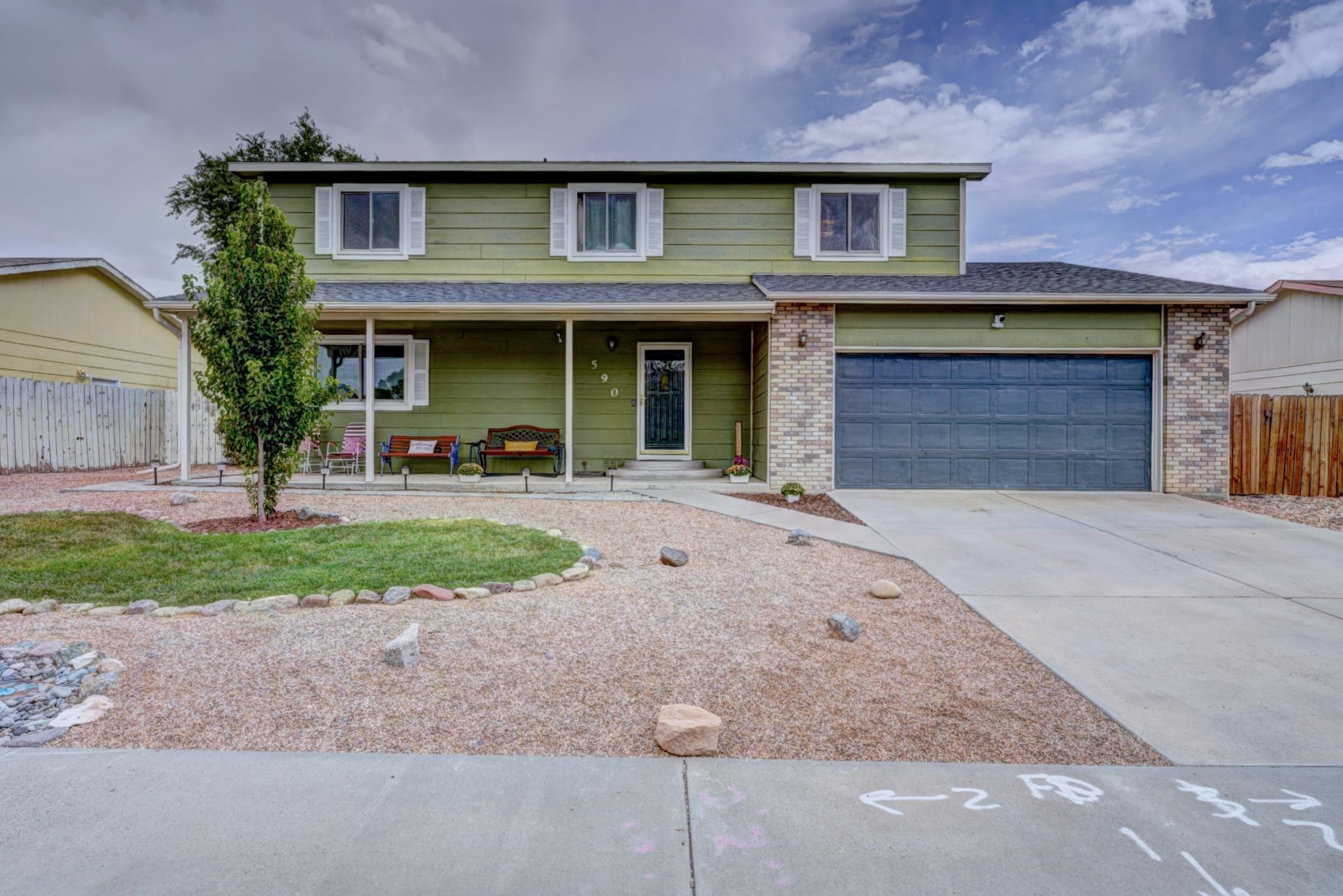 a front view of a house with a yard and a garage