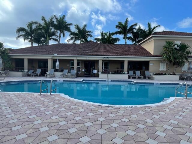 a view of house with swimming pool and a chairs