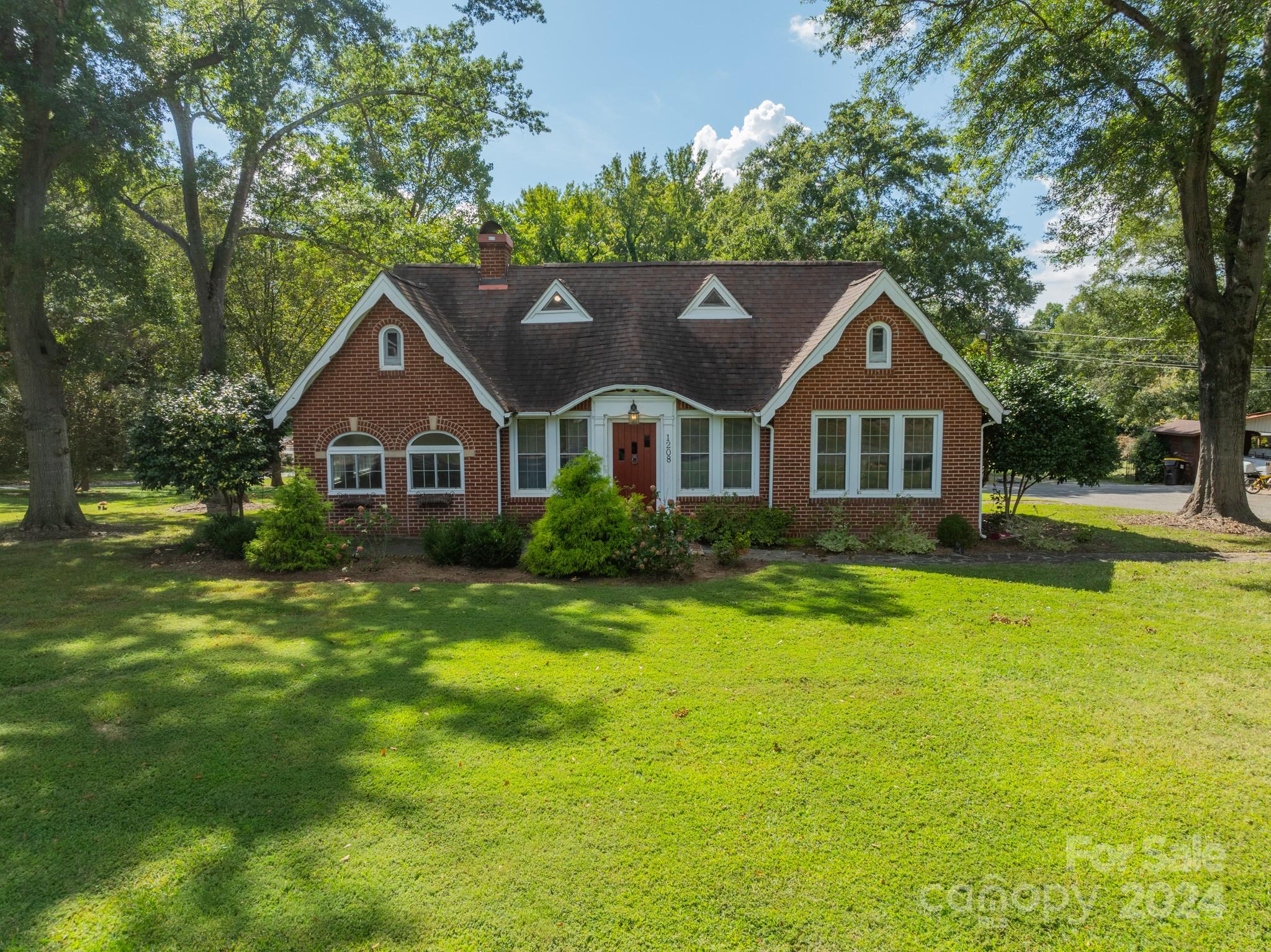 a front view of a house with yard and green space