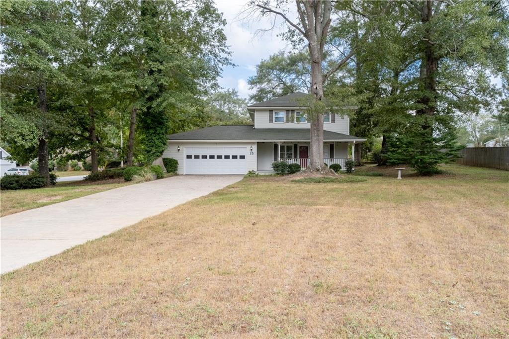 a view of house with yard and car parked