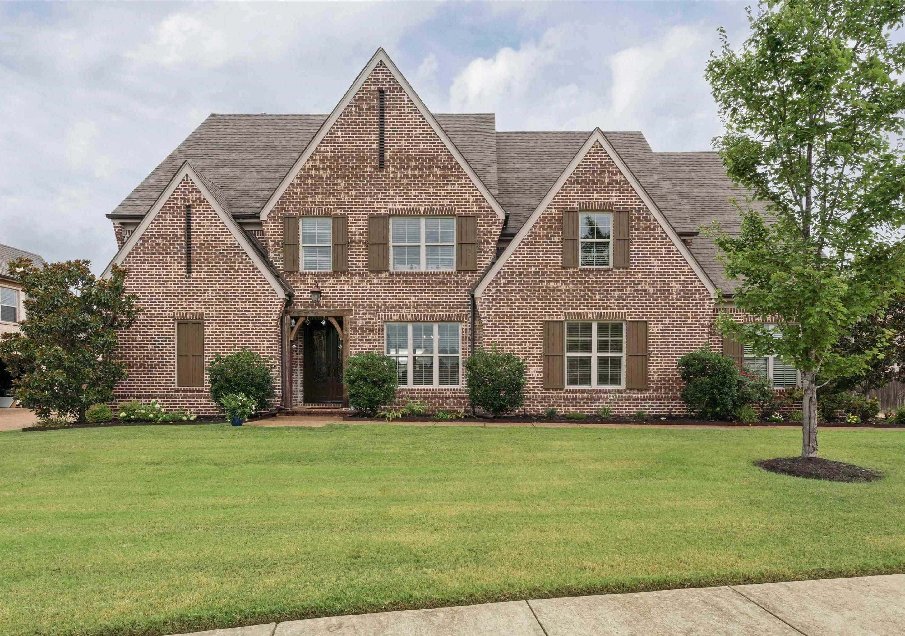 Tudor-style house featuring a front lawn