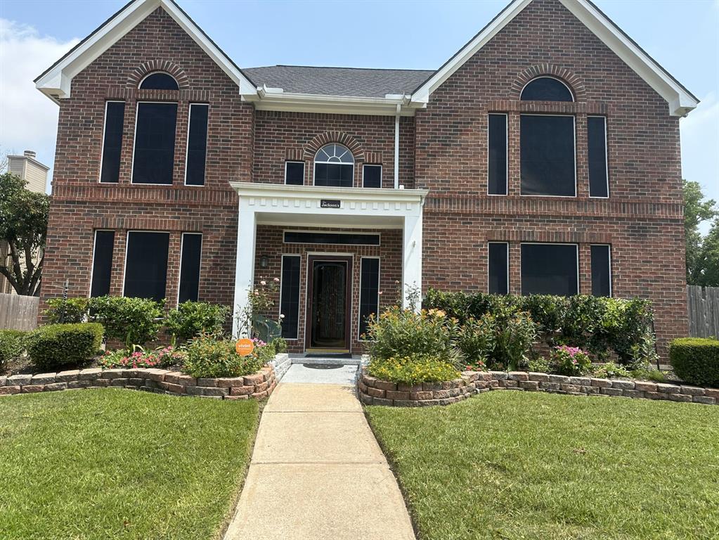 a front view of a house with a yard and potted plants