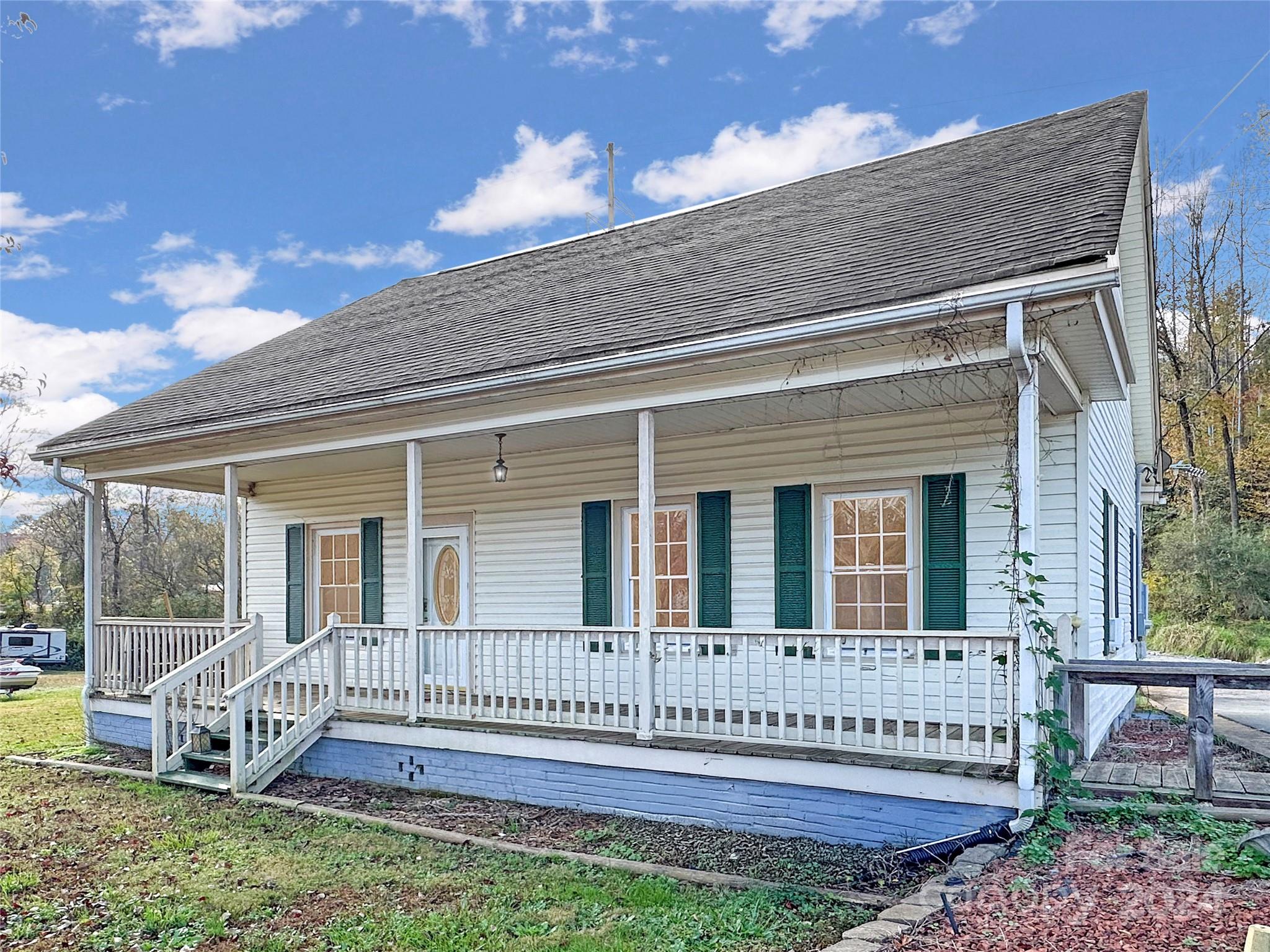 a view of a house with a yard and wooden deck