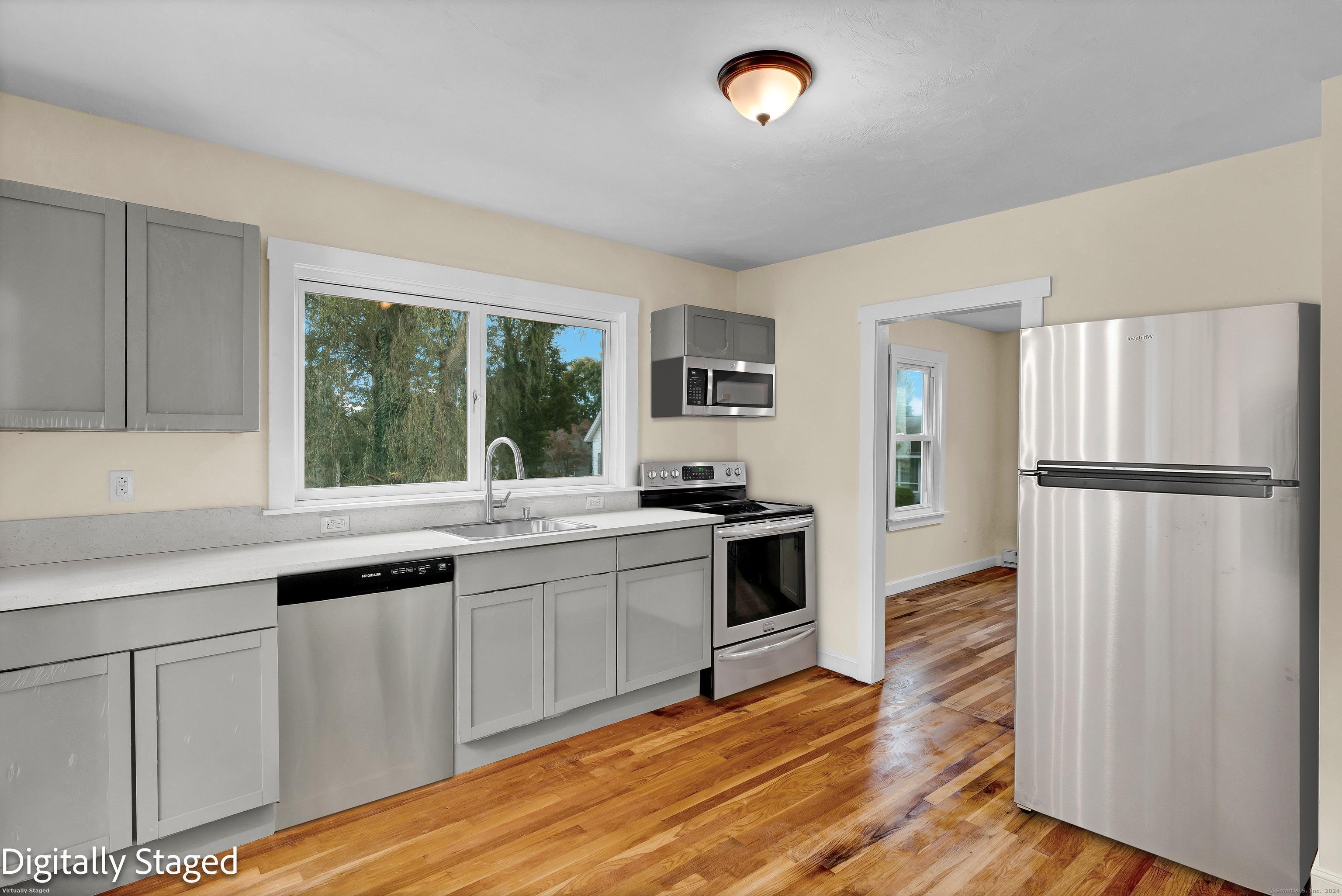 a kitchen with granite countertop a sink appliances and cabinets