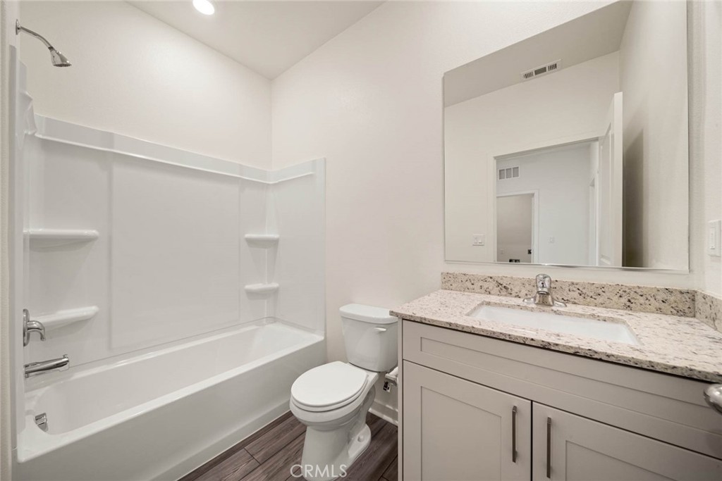 a bathroom with a granite countertop sink mirror toilet and bathtub