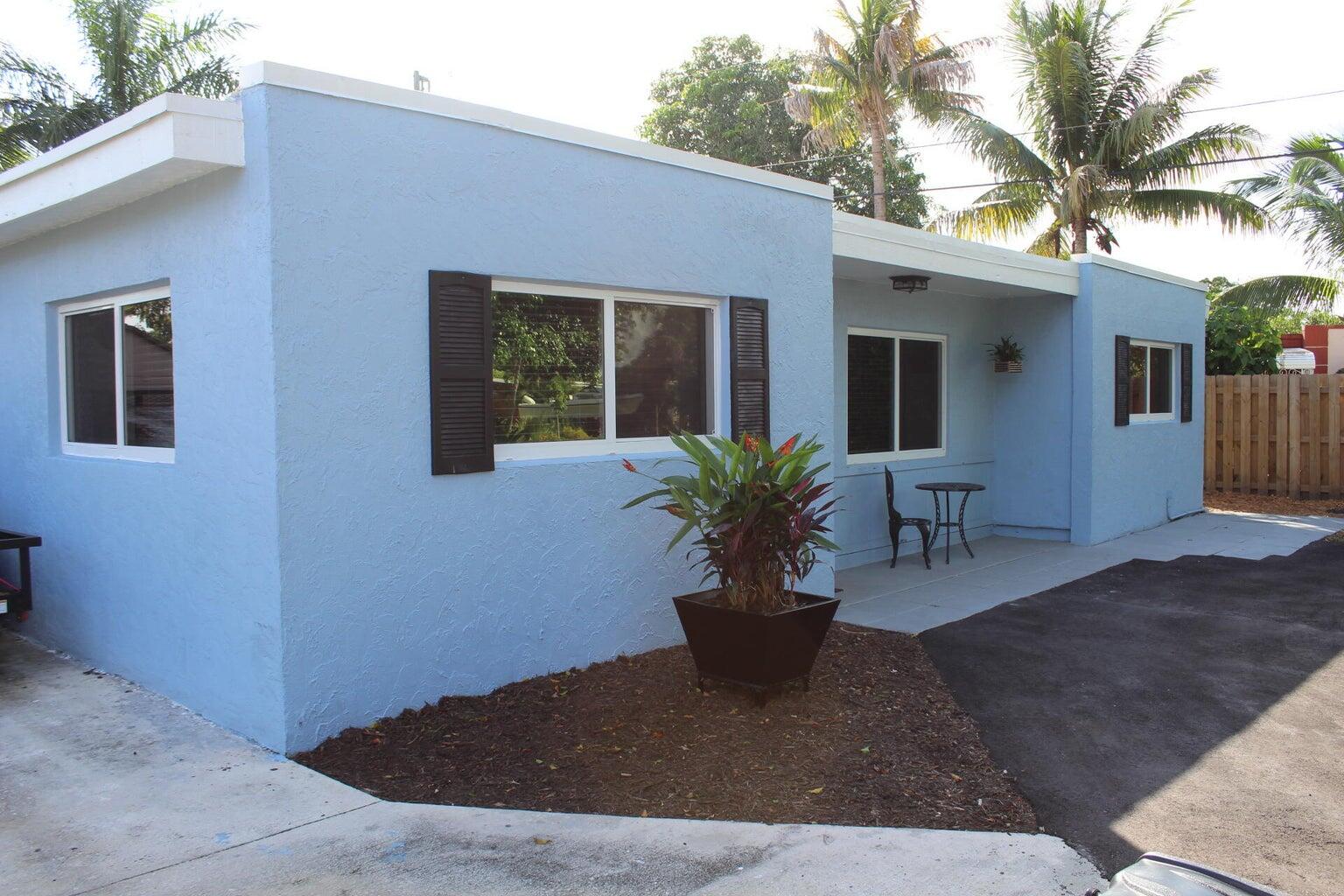 a view of a house with backyard and sitting area