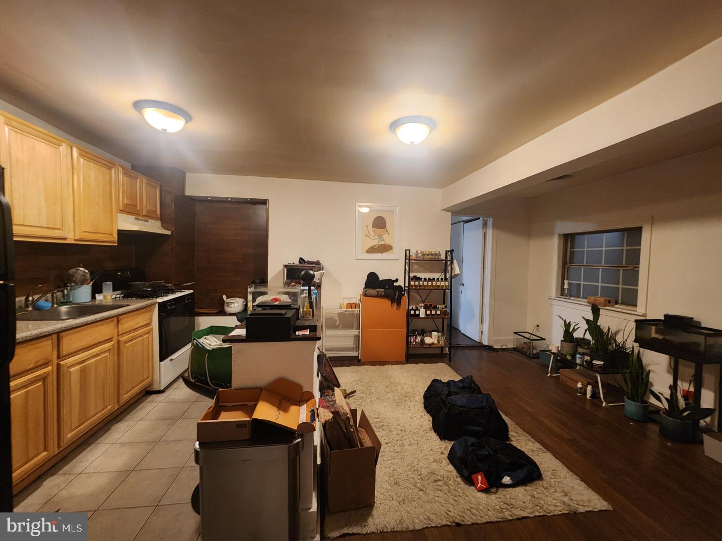 a room with furniture a rug kitchen view and a window