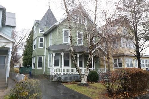 a view of a white house with a large windows and large tree