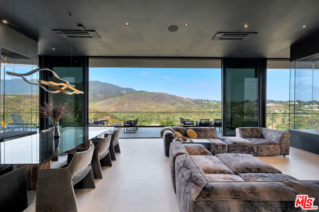 a living room with furniture a floor to ceiling window and a projector