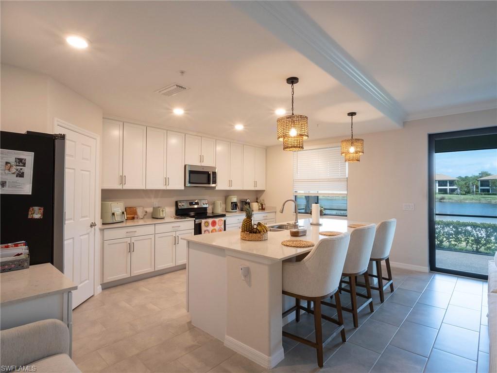 a kitchen with a dining table chairs sink and cabinets