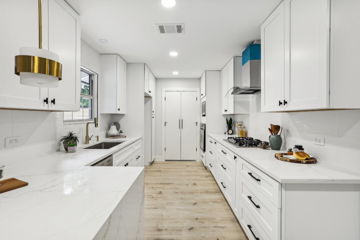 a large white kitchen with cabinets