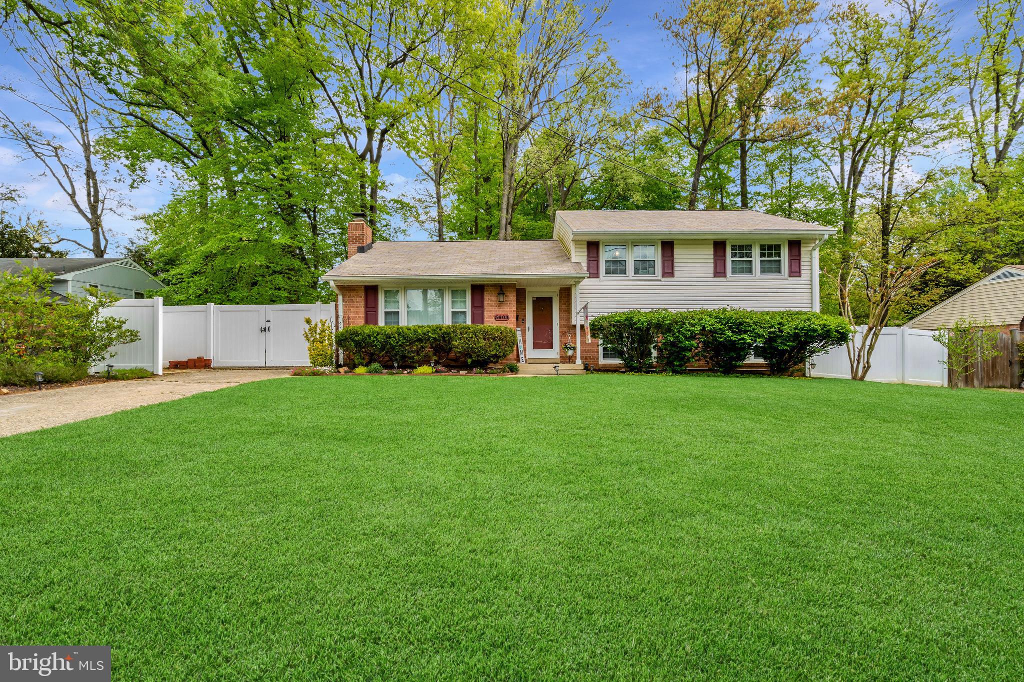 a front view of a house with a yard and trees