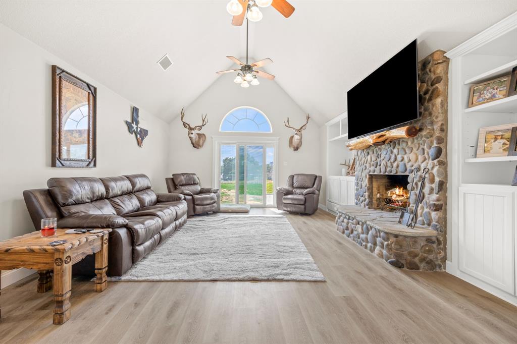 a living room with furniture a flat screen tv and a fireplace