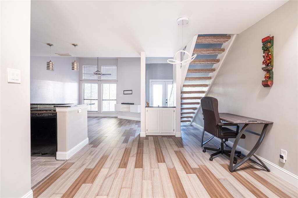 a view of a kitchen with kitchen island wooden floor and stainless steel appliances