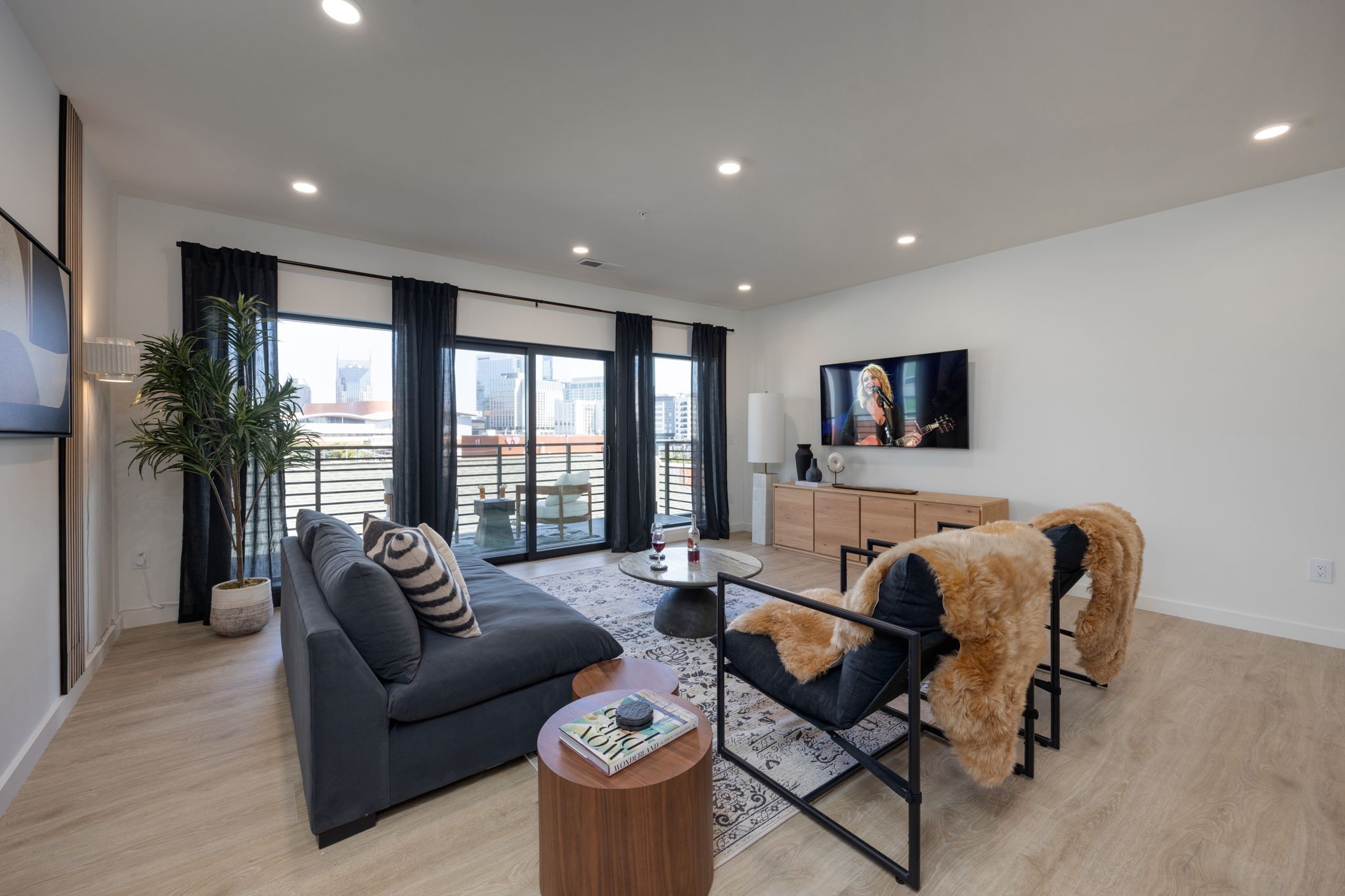 a living room with furniture and floor to ceiling window