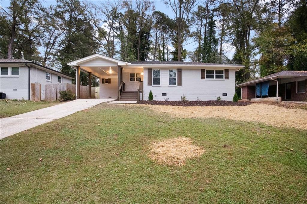 a view of a house with a yard and large tree