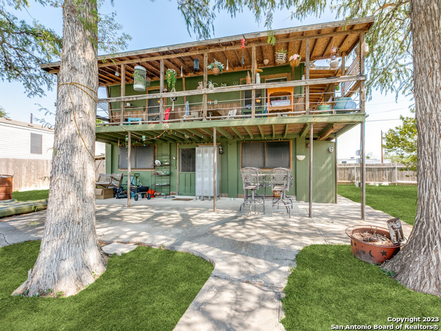 a view of a house with backyard and sitting area