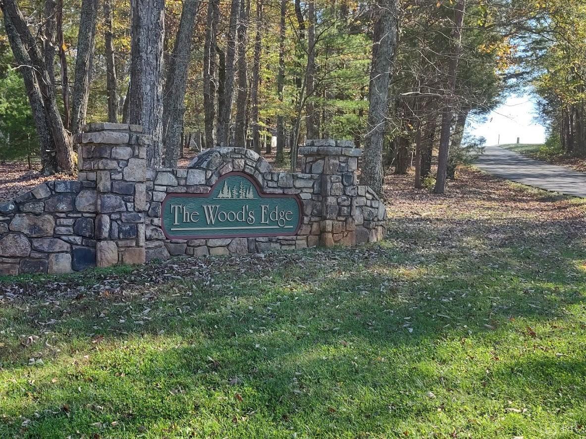 a sign board with tall trees