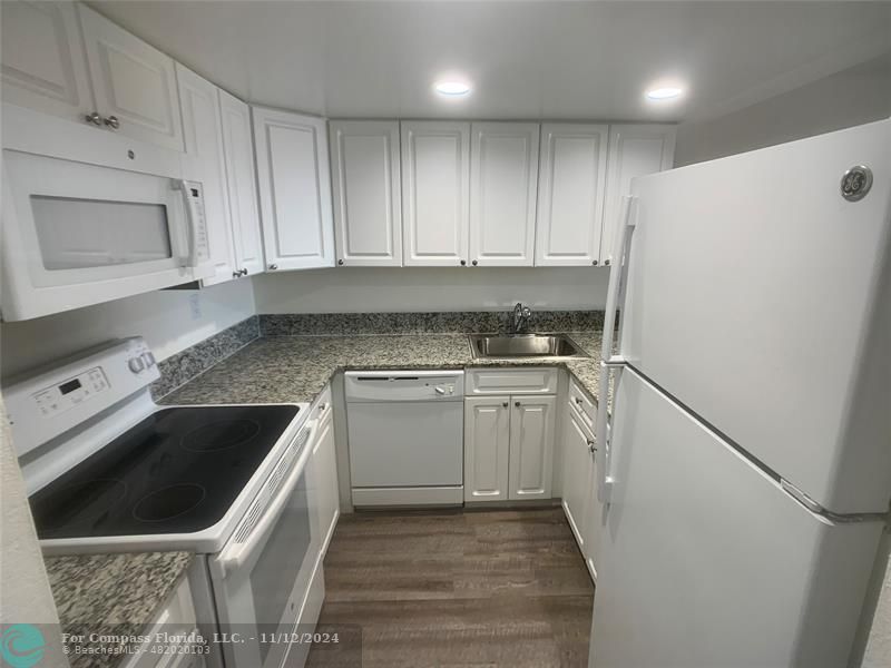 a kitchen with a sink a refrigerator and cabinets