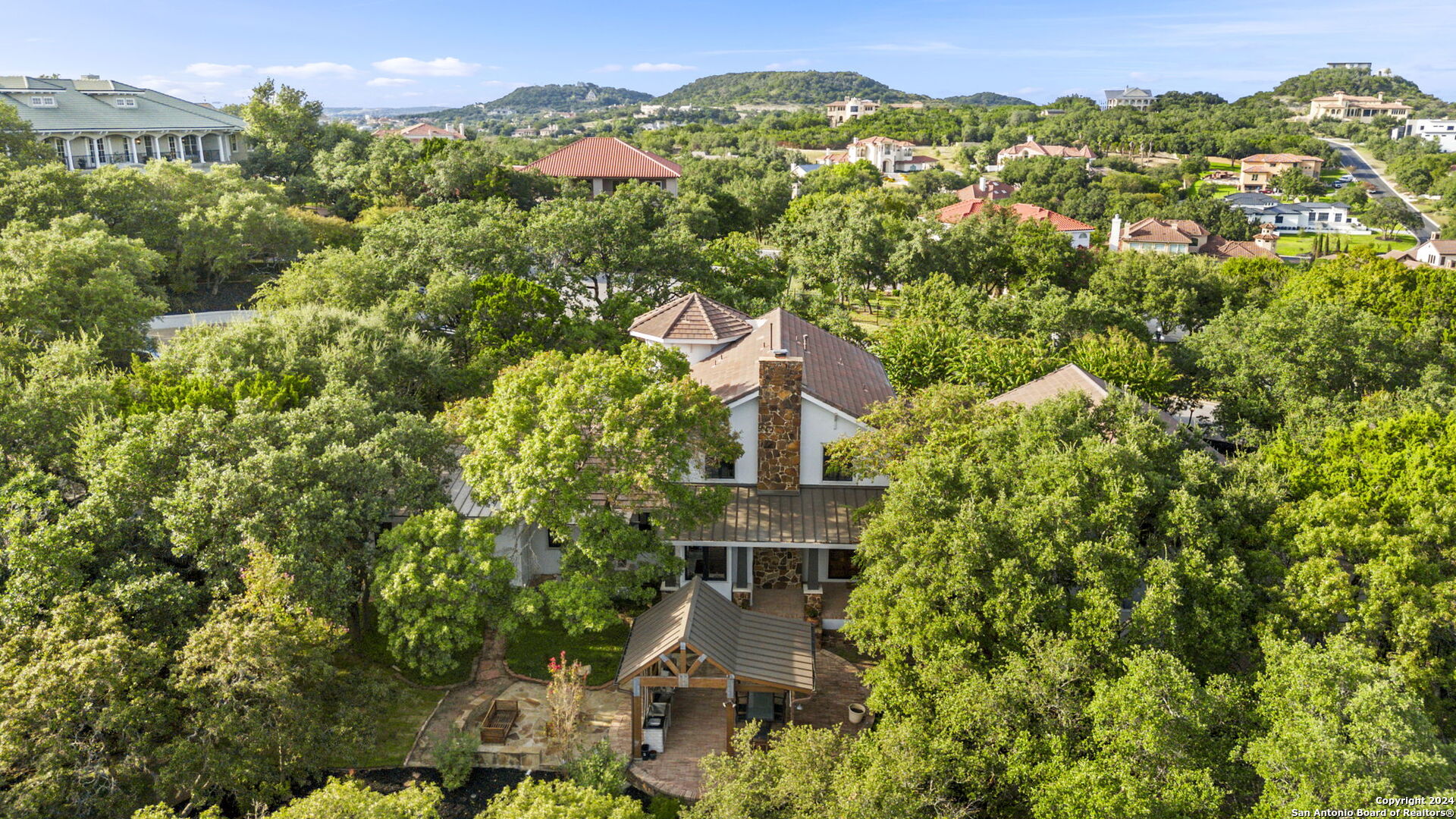 an aerial view of residential houses with outdoor space and trees