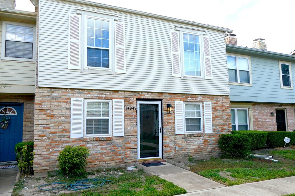 a view of a brick house with a large windows and a yard