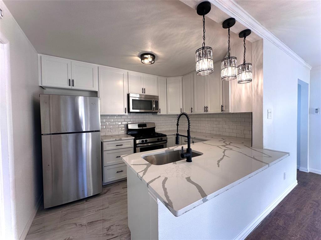 a kitchen with kitchen island a counter space cabinets and stainless steel appliances