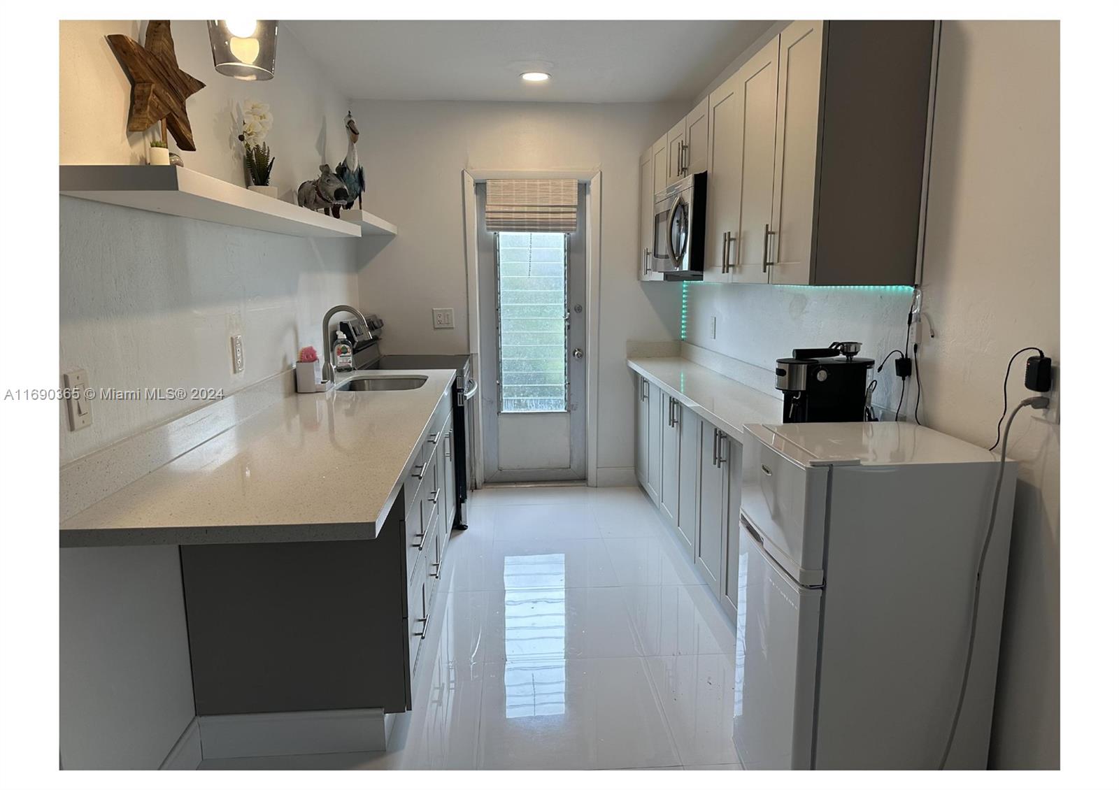 a kitchen with a sink dishwasher a refrigerator and cabinets