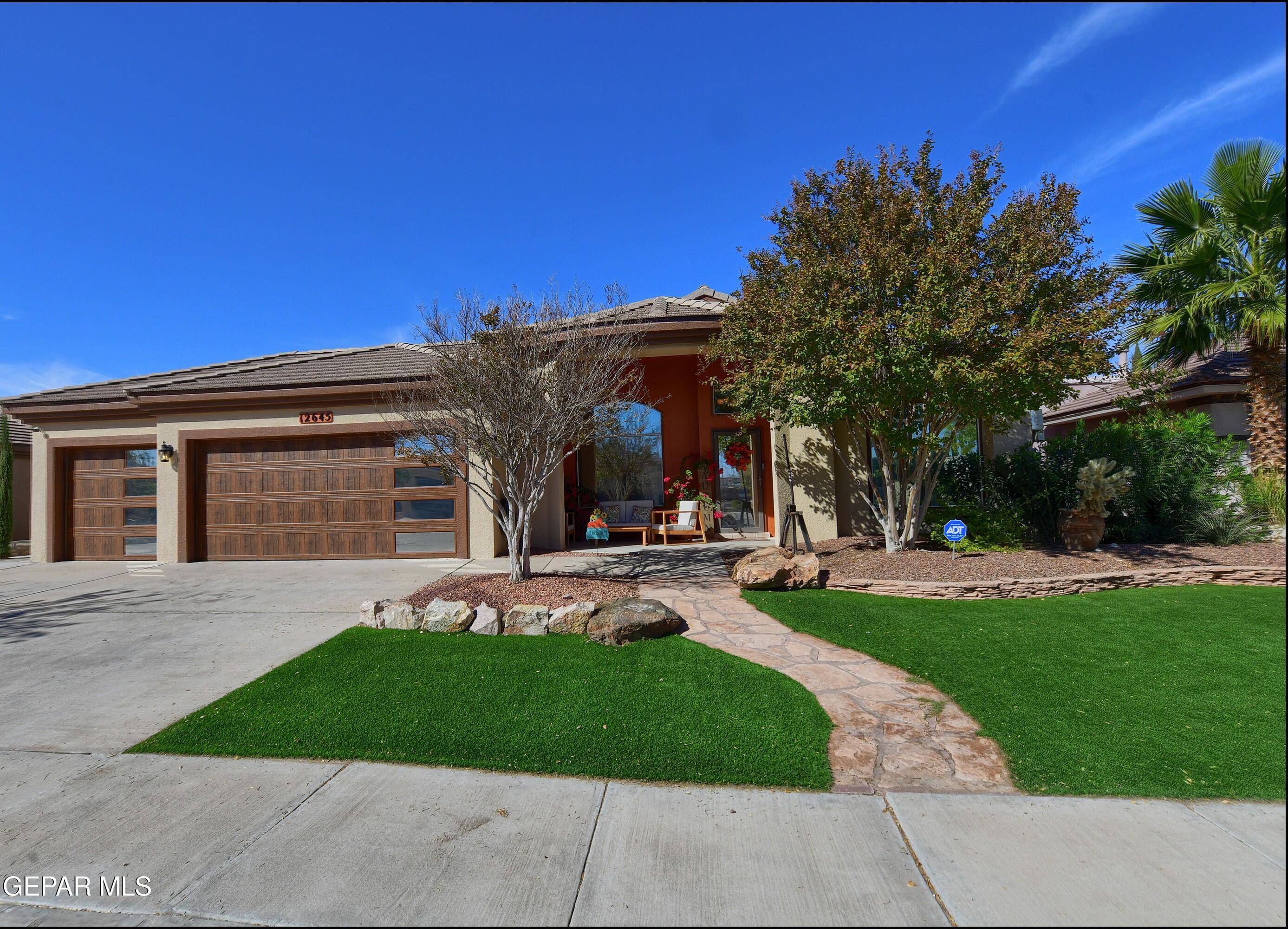 a front view of a house with a garden and yard