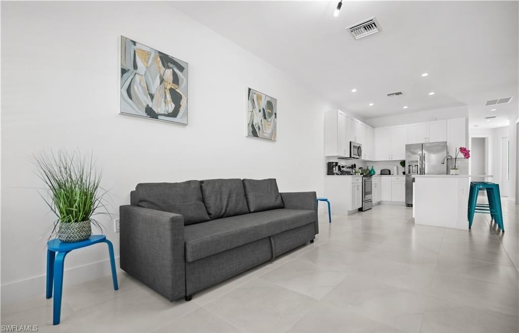 a living room with furniture and kitchen view