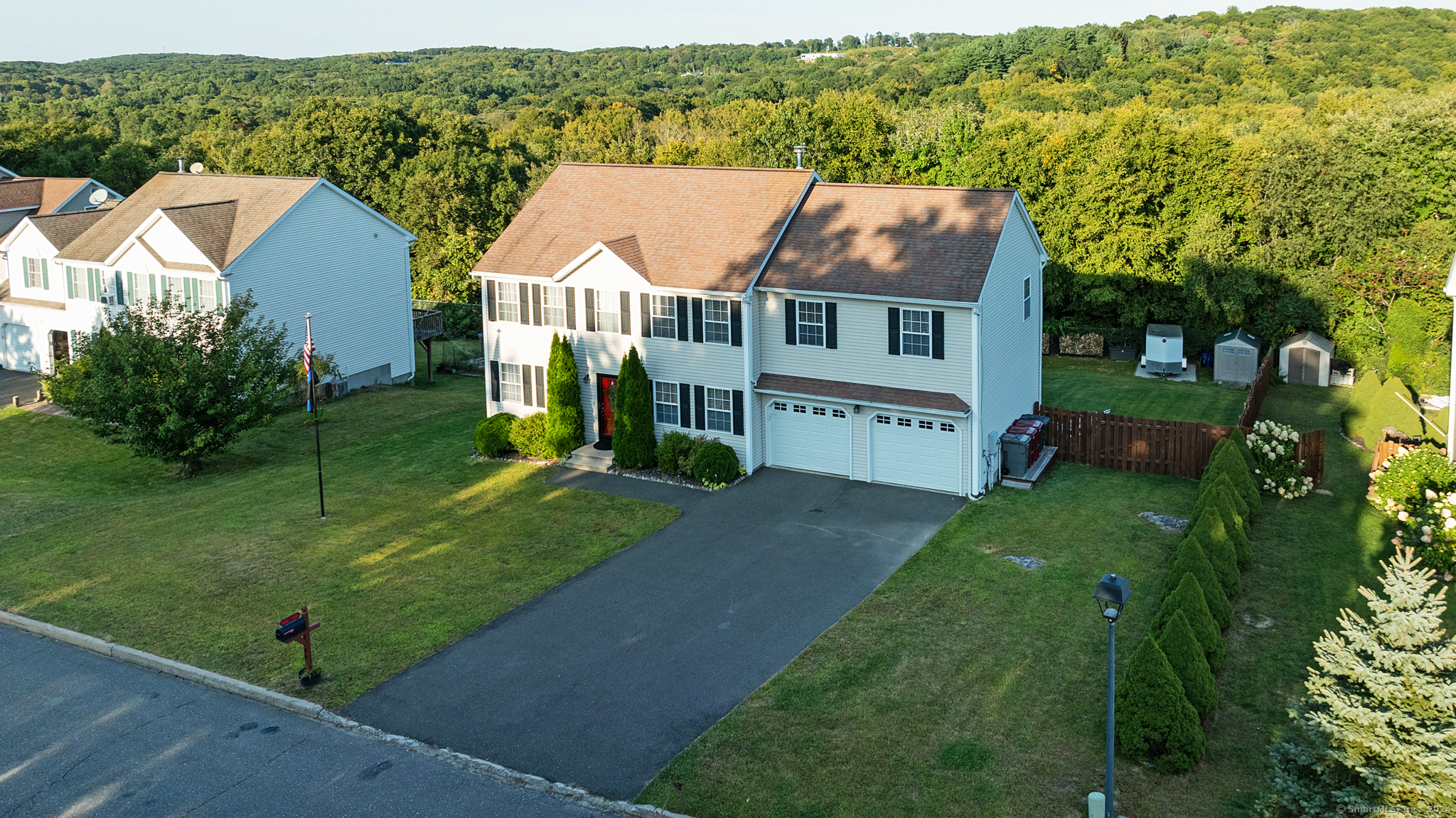 an aerial view of residential houses with outdoor space and trees