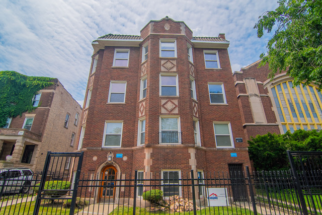 a front view of a residential apartment building with a yard