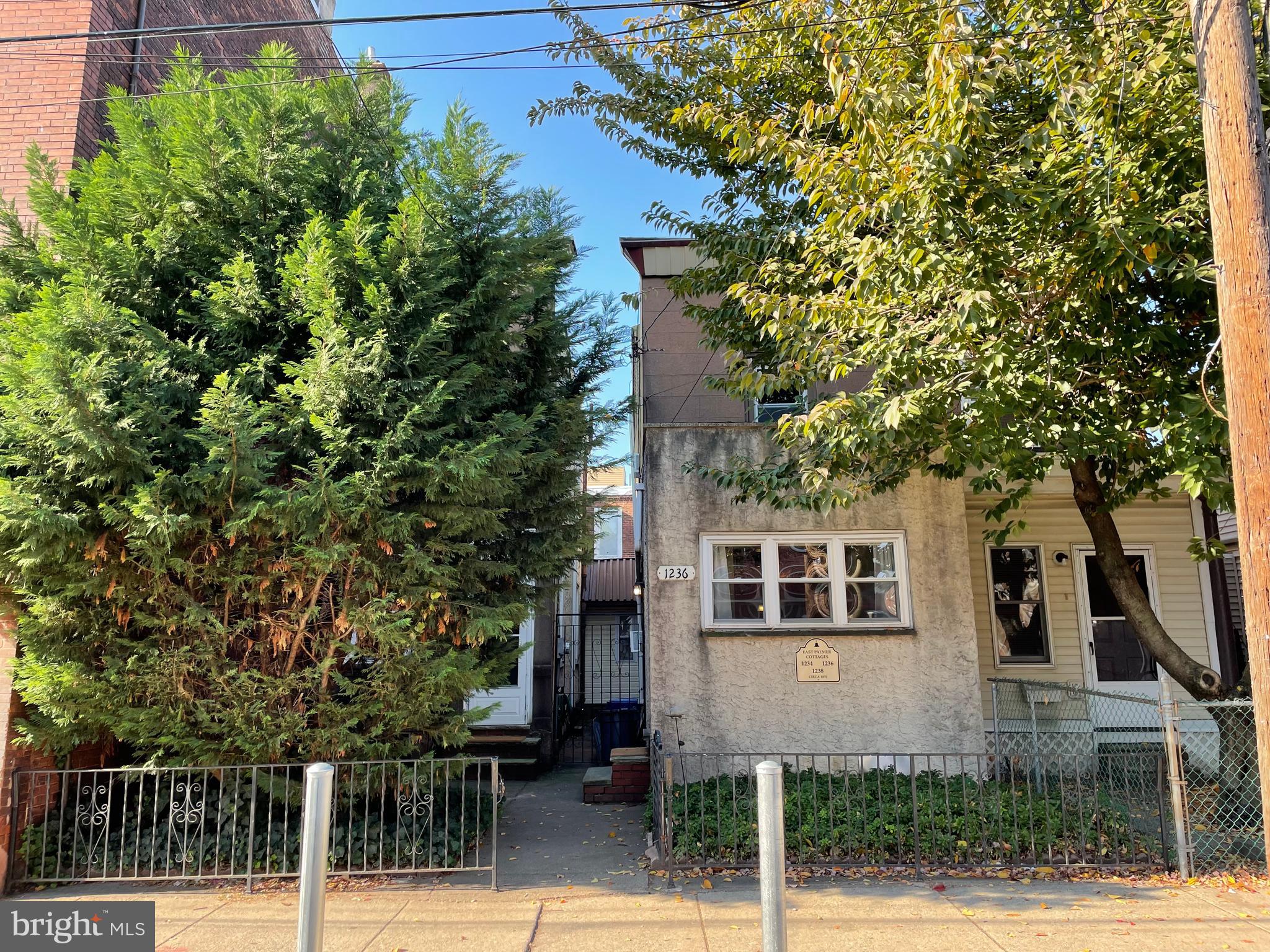 a front view of a house with a tree