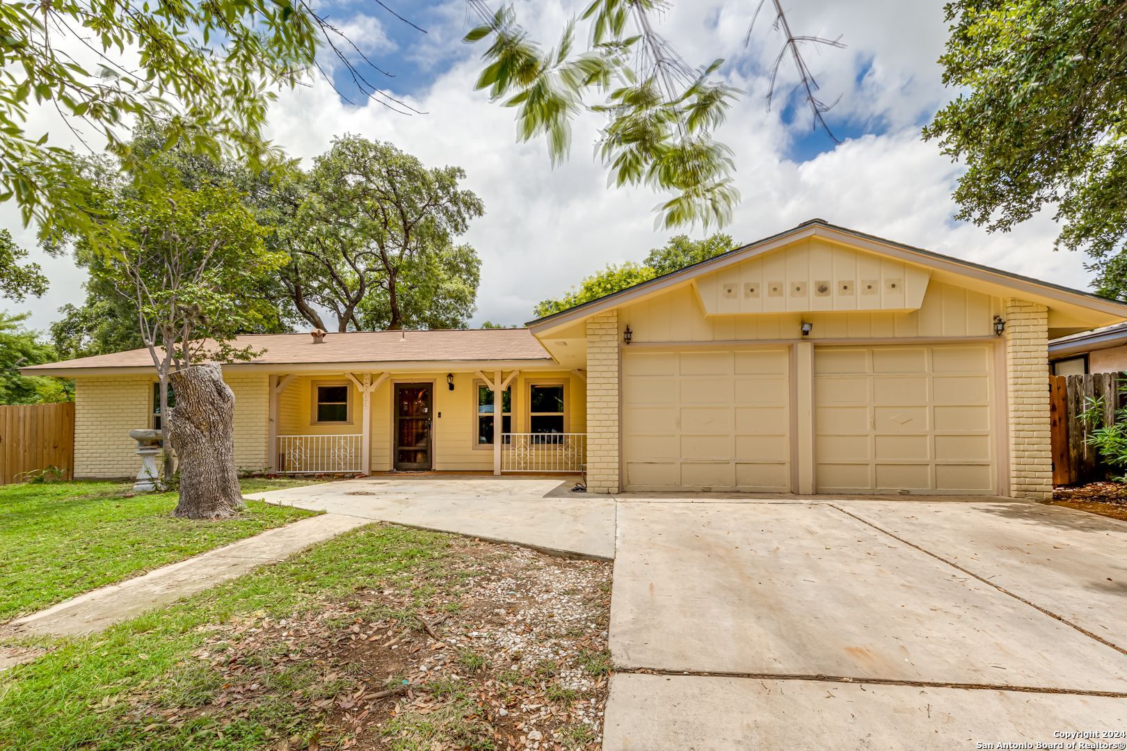 a front view of a house with a garden and yard