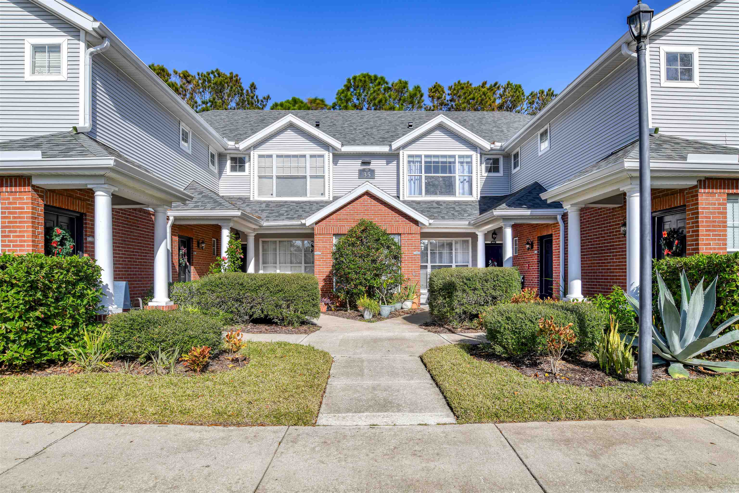 a front view of a house with yard and green space