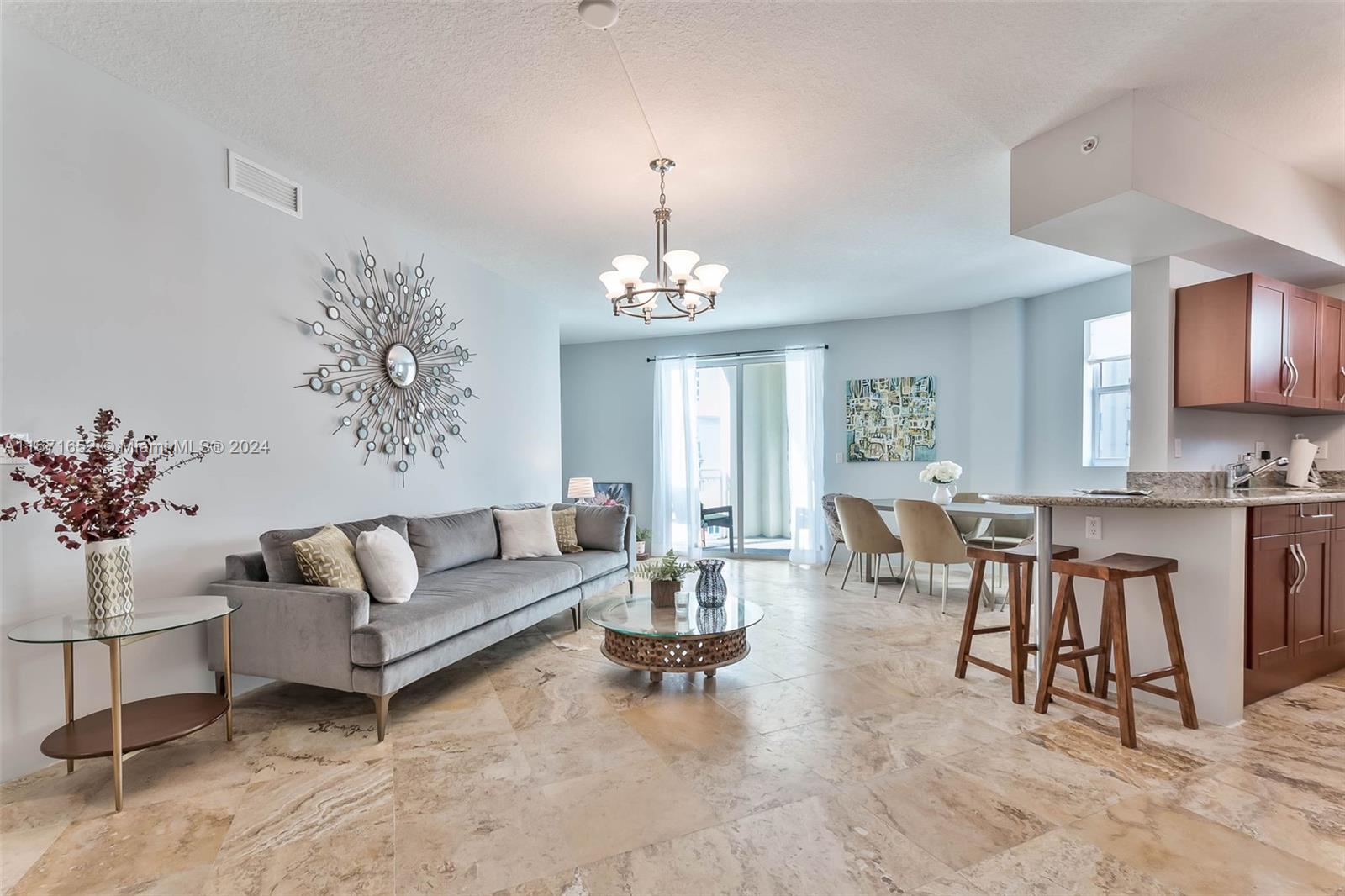 a living room with furniture a dining table and a chandelier