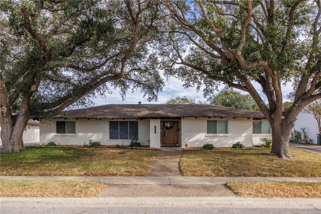 a front view of a house with a tree