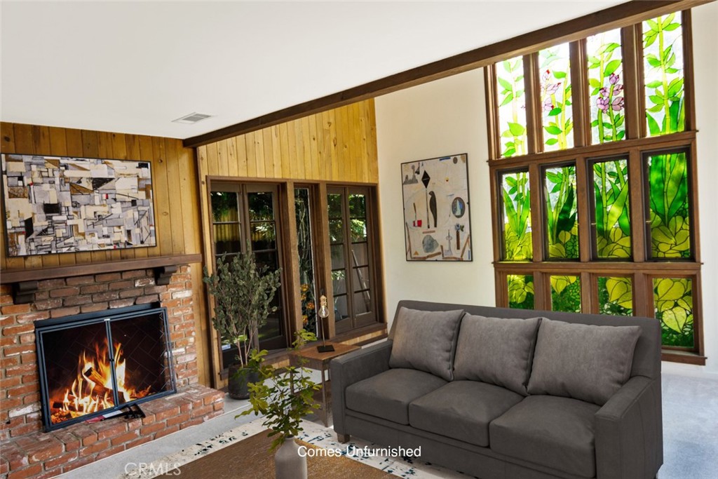 a living room with furniture a fireplace and a floor to ceiling window