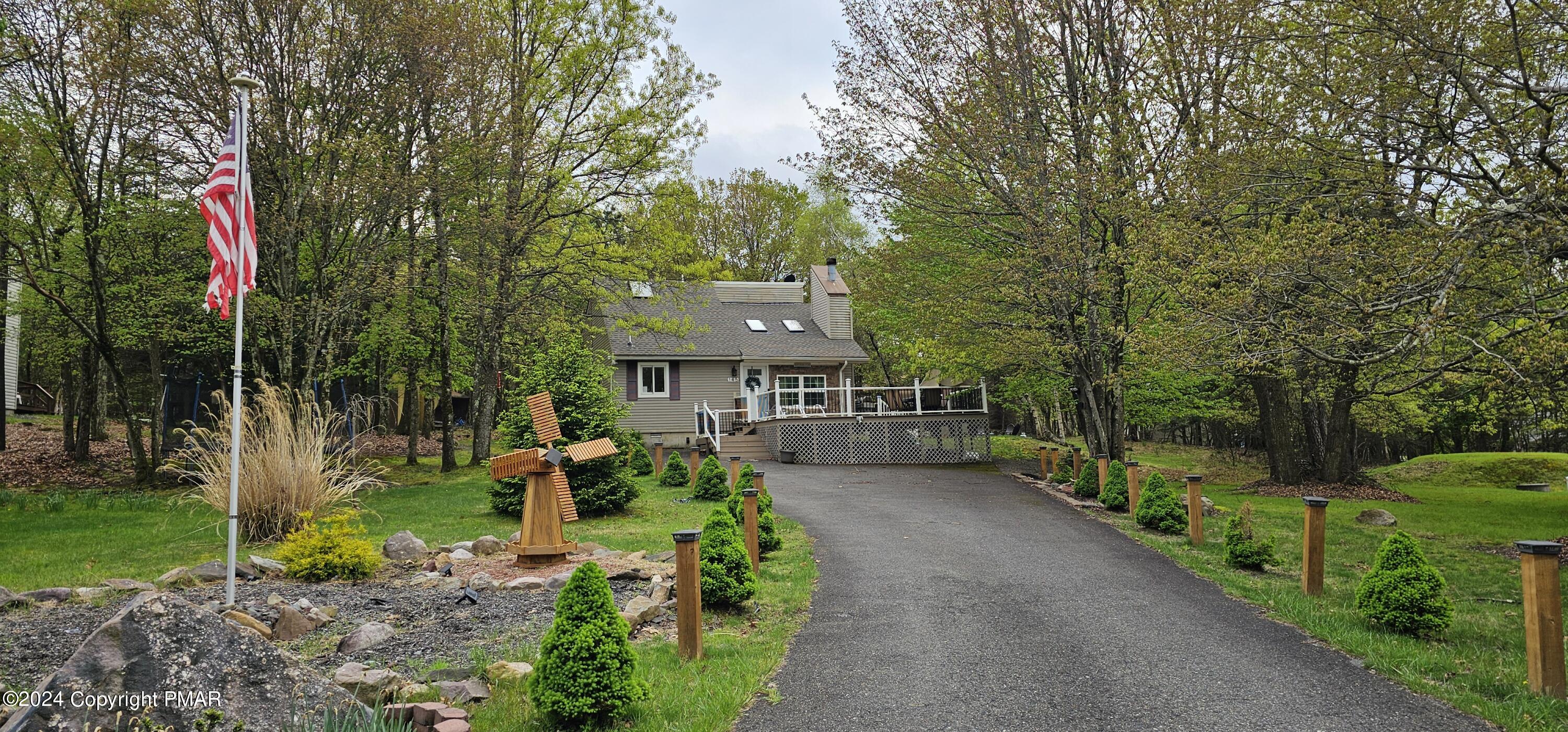 a view of a house with a big yard and large trees